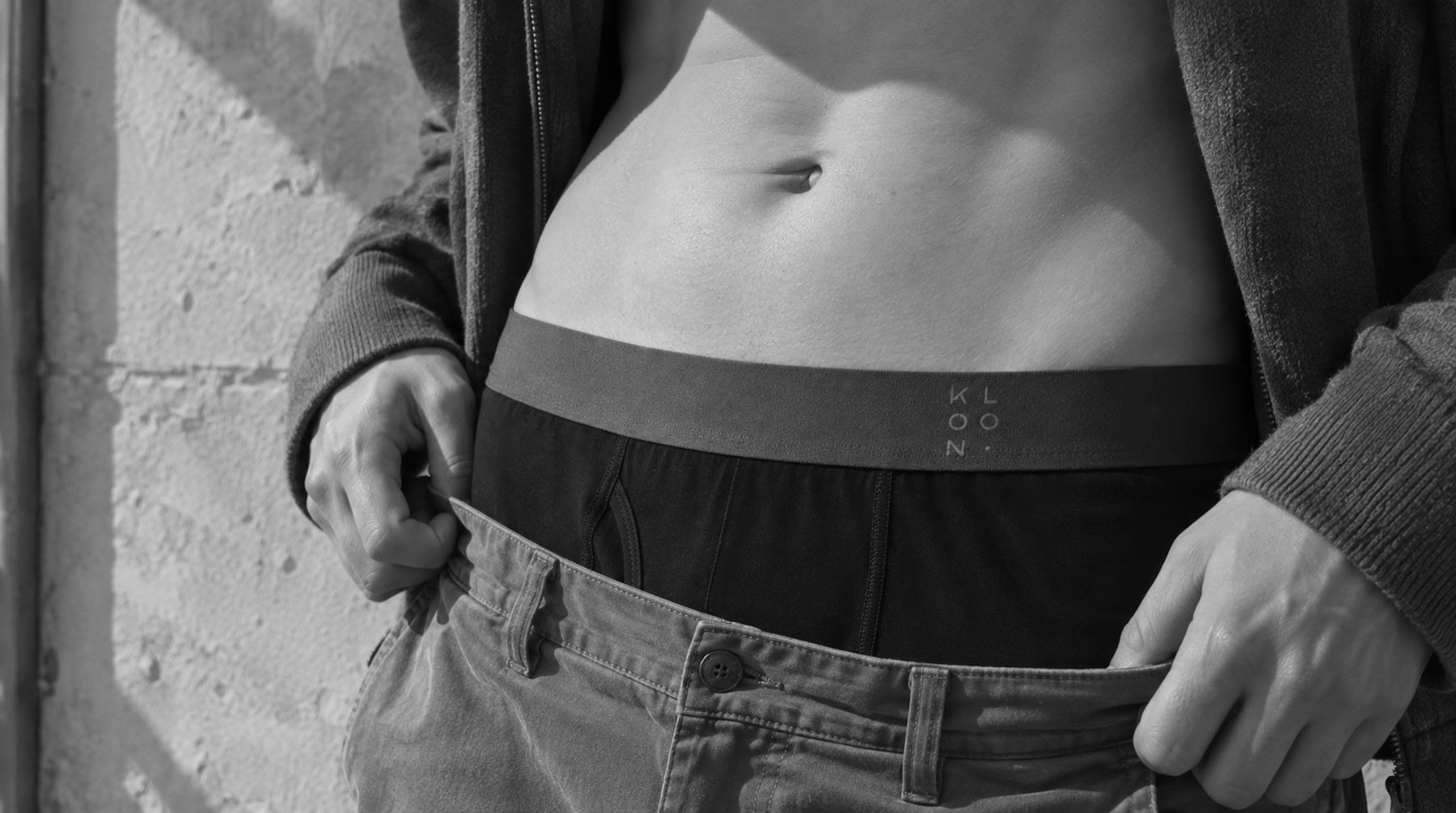 KLOON waistband, candid, jeans pulled down against a concrete wall