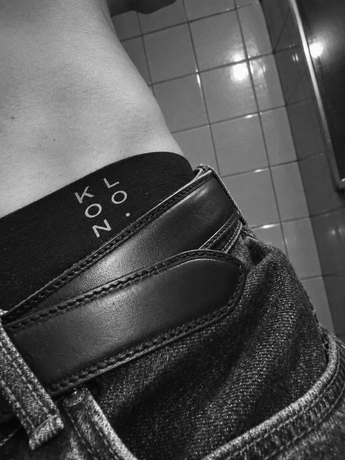 Close-up of the KLOON waistband above jeans and a leather belt